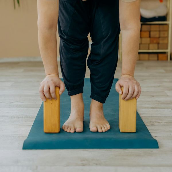Person doing a stretching yoga pose against a golden backdrop.